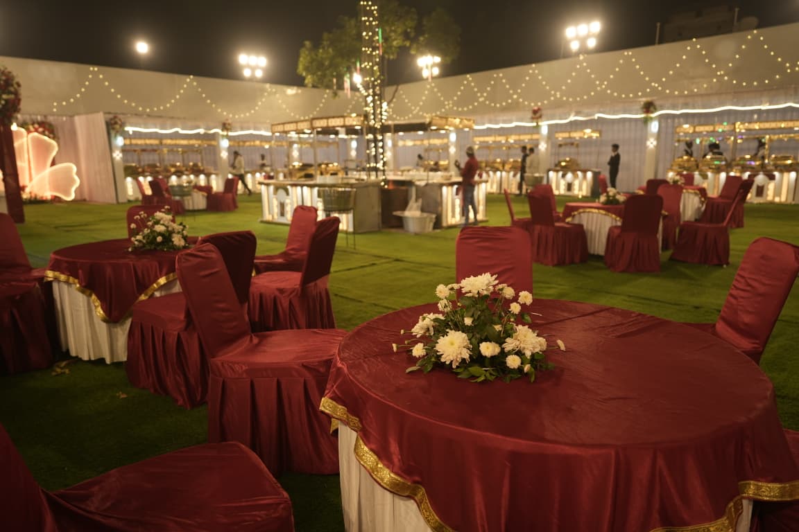 Elegant outdoor table settings with maroon linen and flower centrepieces