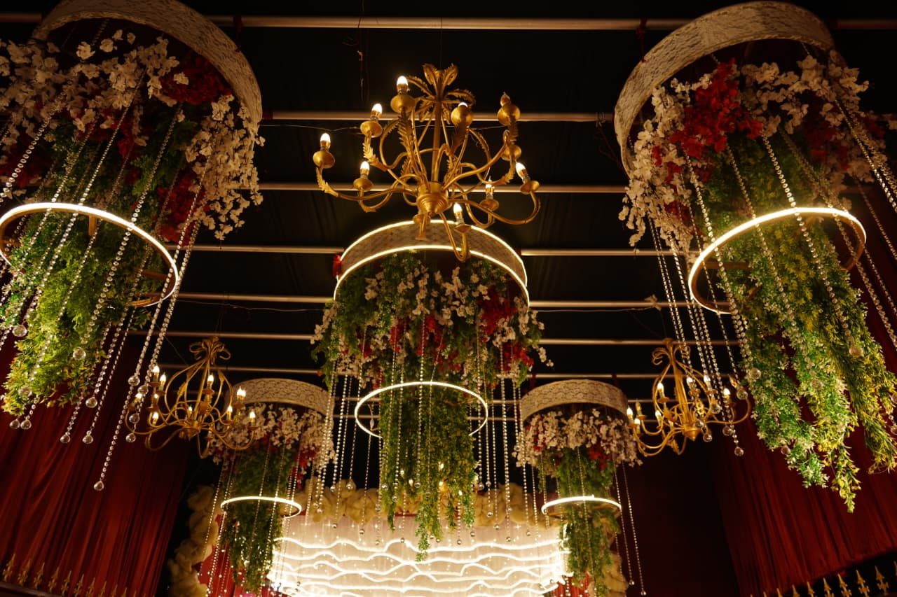 Banquet hall ceiling décor with gold chandeliers and crystal drapes
