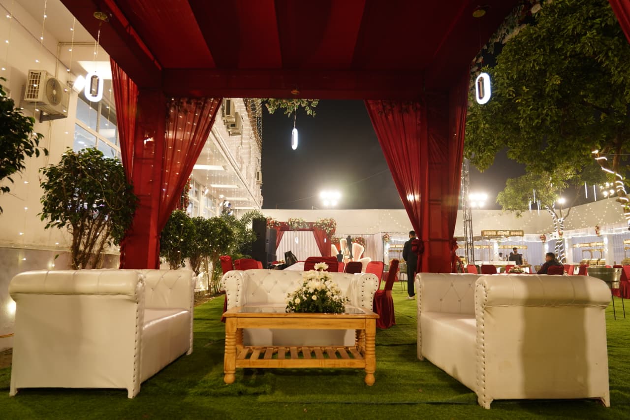VIP lounge seating on the lawn under red drape canopy