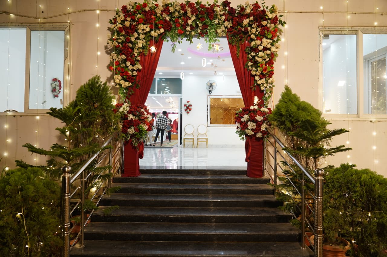 Decorated staircase entrance with red and white floral arch